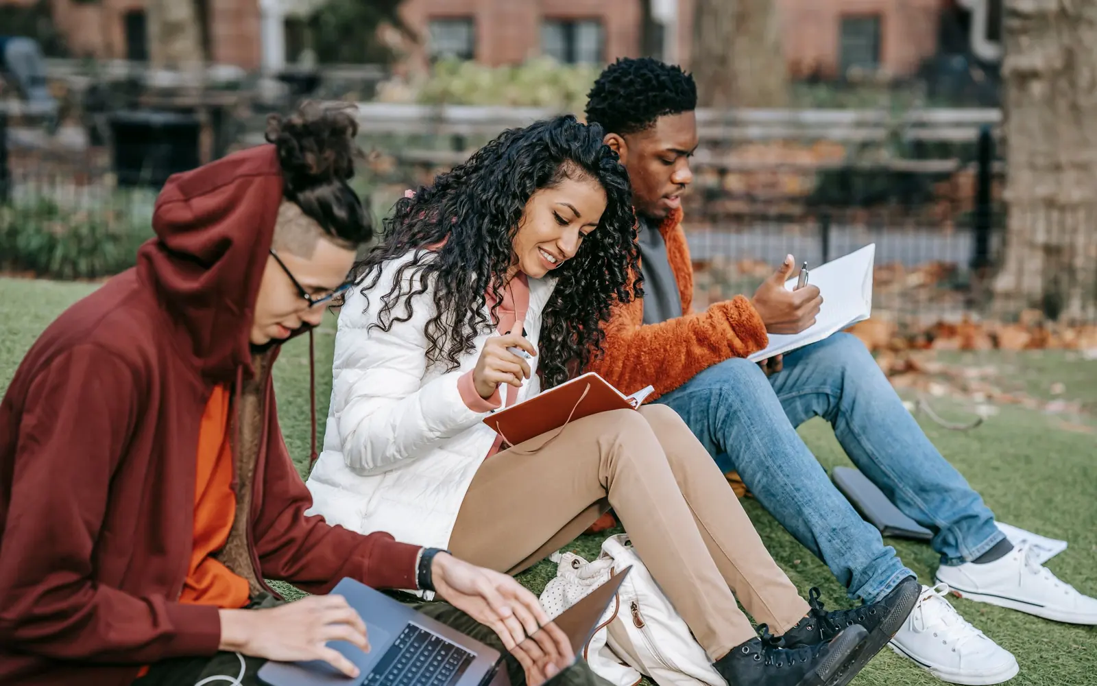 Grupo diverso de estudantes colaborando ao ar livre