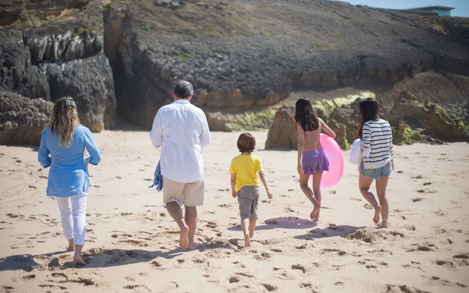 Família caminhando junta em uma praia durante uma viagem